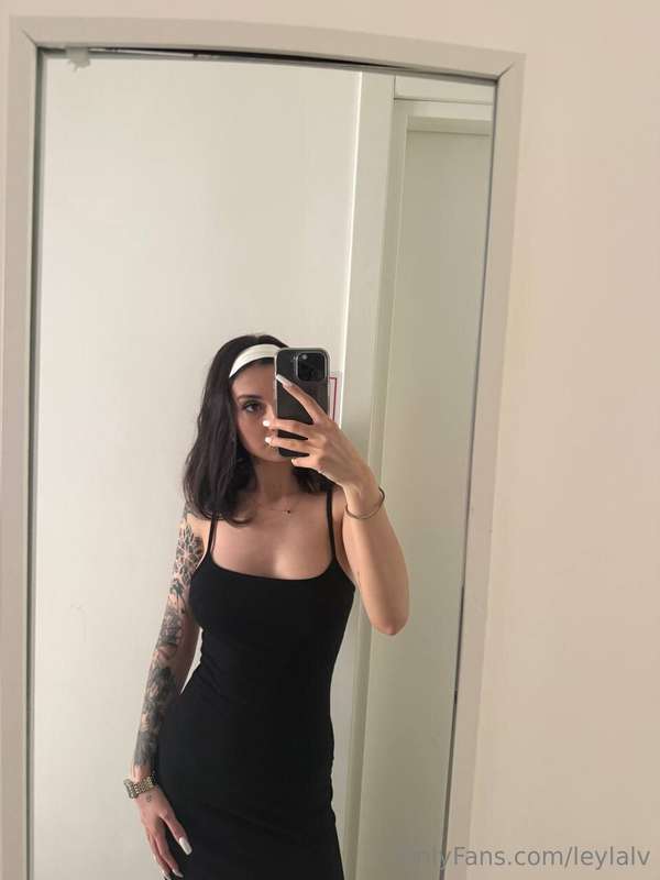 I'm wearing a black dress that emphasizes my curves in a sex..